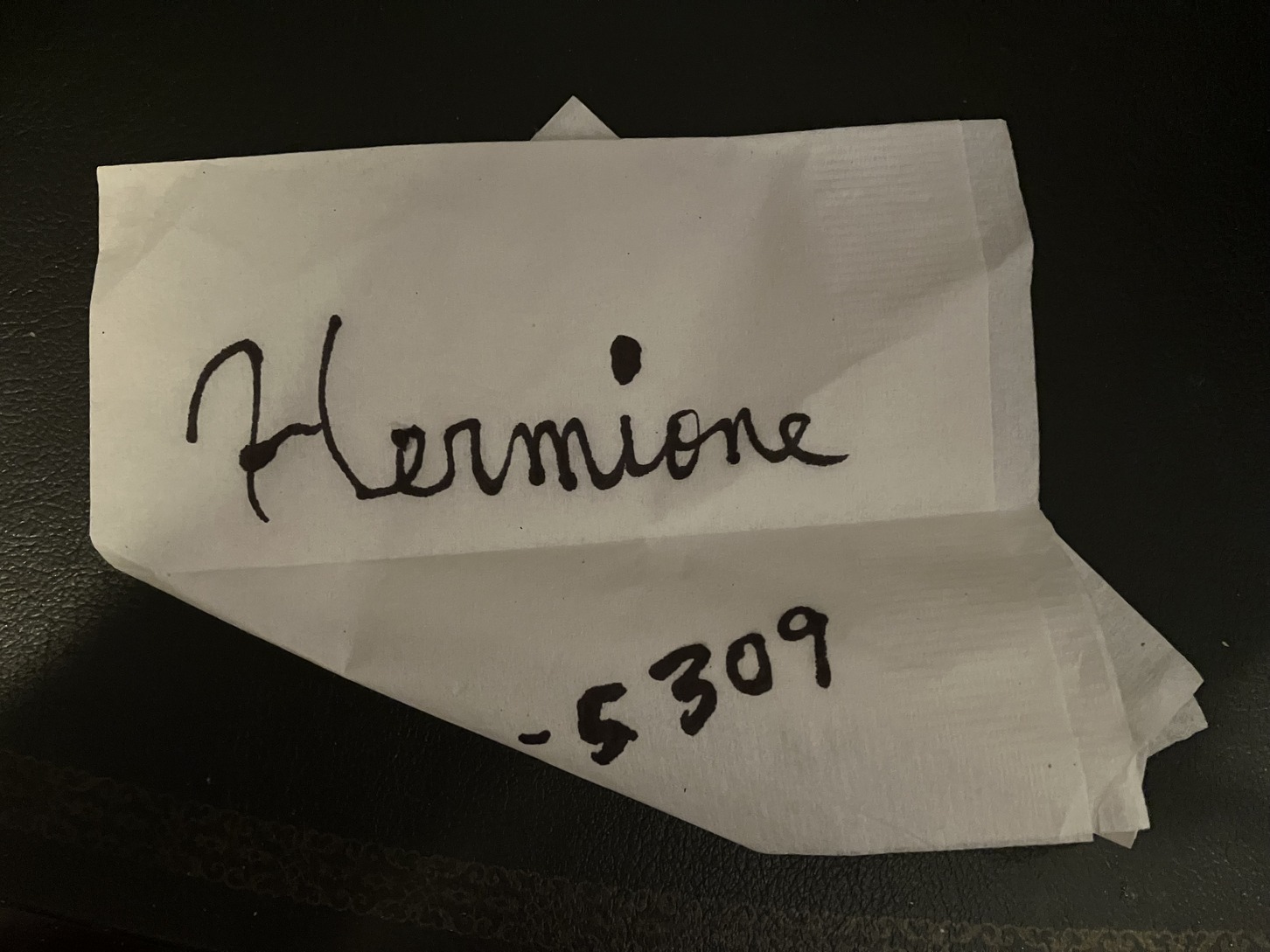 Hermione's handwritten phone number on napkin